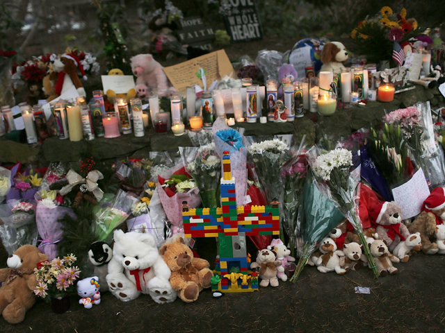 Teddy bears, flowers and candles in memory of those killed, are left at a memorial down the street from the Sandy Hook School December 16, 2012 in Newtown, Connecticut. Twenty-six people were shot dead, including twenty children, after a gunman identified as Adam Lanza opened fire at Sandy Hook Elementary School. (Photo by Spencer Platt/Getty Images)