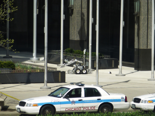 A police bomb squad robot inspects a suspicious package in a plaza on Michigan Avenue on April 30, 2013. (Credit: Rachel Azark)