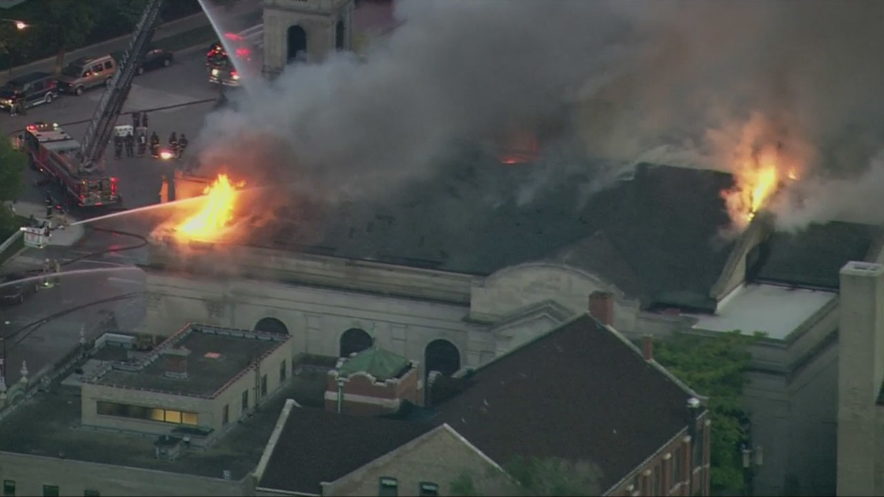Firefighters pour water through the roof of Shrine of Christ the King, a landmark church in the Woodlawn neighborhood. The St. Gelasius Church building received city landmark status in 2004. (Credit: CBS)