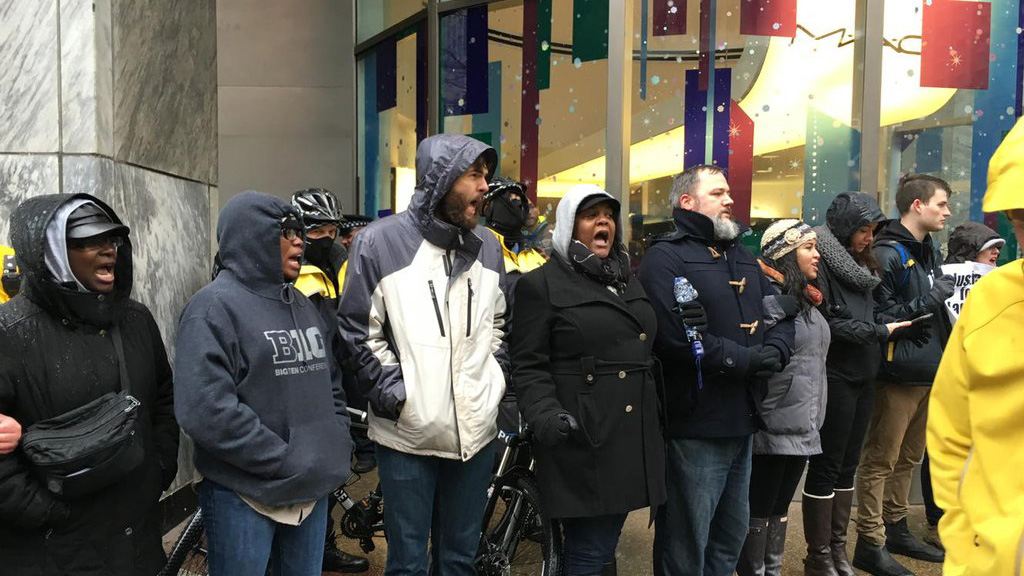 Demonstrators block an entrance to Water Tower Place during a march to protest the fatal police shooting of 17-year-old Laquan McDonald. (Credit: CBS)
