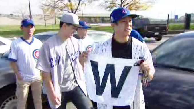 Cubs fan John Ho waves his W flag on the road back to Chicago. (CBS)
