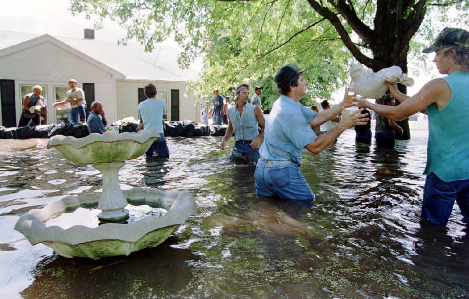 Volunteers try to save farmer Bill Kennedy's home in Prairie du Rocher, Illinois, from floodwaters after the Army Corps of Engineers intentionally broke a nearby farmland levee to relieve pressure on the downtown's levee in August 1993. The town is a historically significant 18th century French settlement.